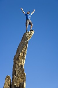 Man on the summit of a rock spire.