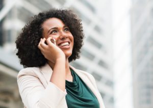 woman happy and smiling, on the phone to colleague