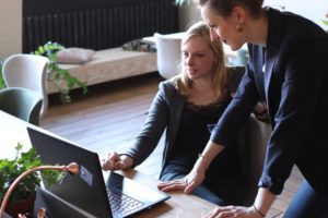 two business women looking at computer