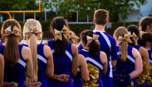 community cheering people on, cheerleaders standing in a row